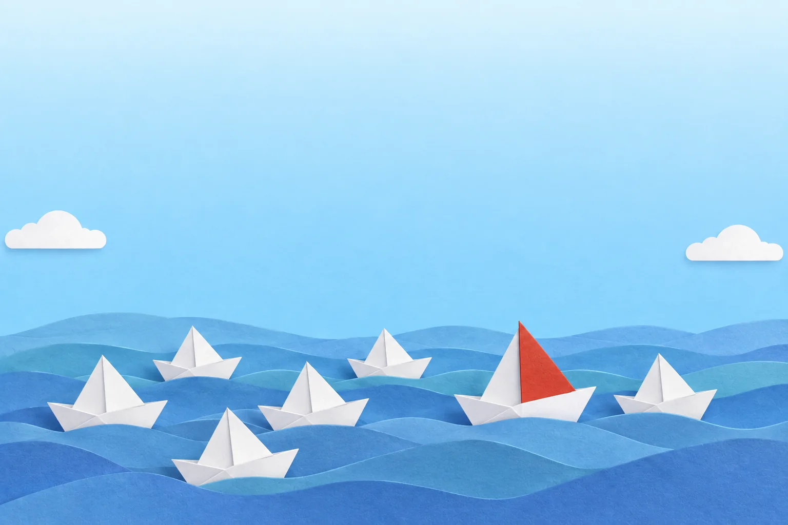 Paper boats on the waves, one with a red sail